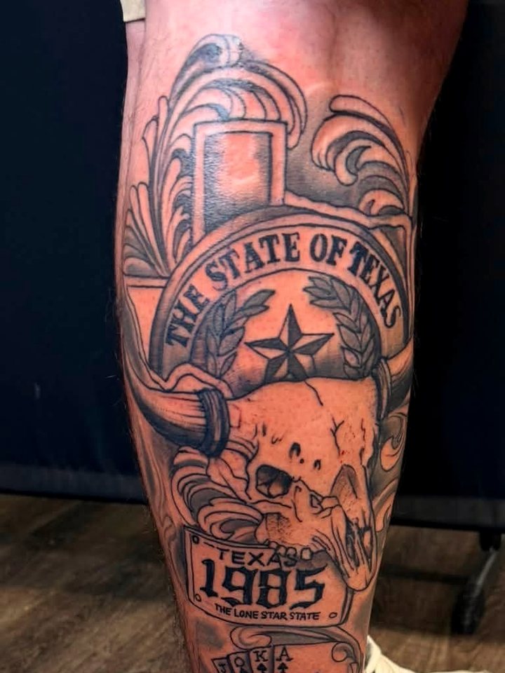 Ornamental black-and-grey calf piece - a State of Texas banner over a longhorn skull and a 1985 plate.